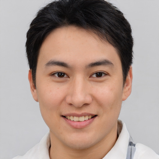 Joyful asian young-adult male with short  brown hair and brown eyes