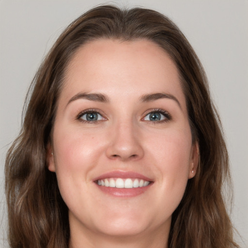 Joyful white young-adult female with long  brown hair and grey eyes