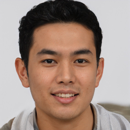 Joyful latino young-adult male with short  brown hair and brown eyes