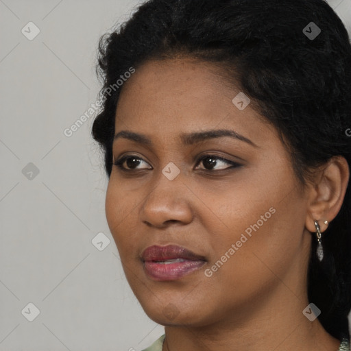 Joyful black young-adult female with long  brown hair and brown eyes