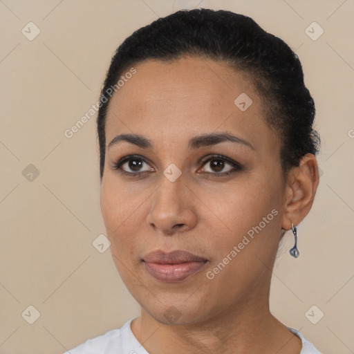 Joyful black young-adult female with short  black hair and brown eyes