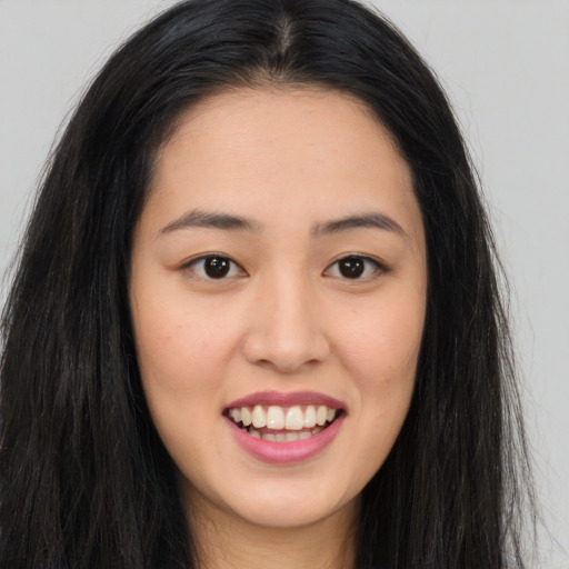Joyful asian young-adult female with long  brown hair and brown eyes