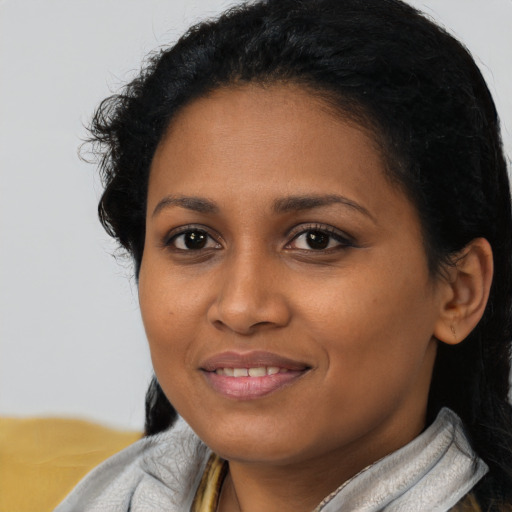 Joyful black young-adult female with medium  black hair and brown eyes