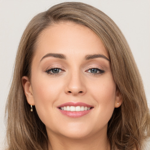 Joyful white young-adult female with long  brown hair and brown eyes