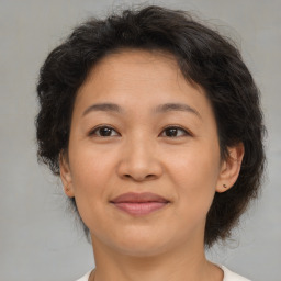 Joyful asian adult female with medium  brown hair and brown eyes