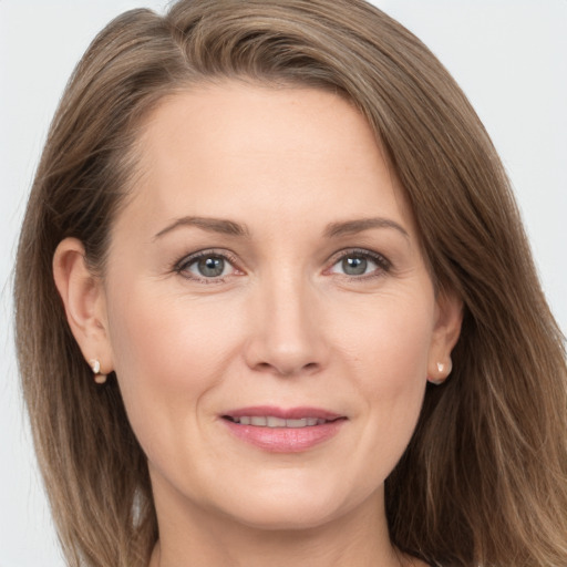 Joyful white adult female with long  brown hair and grey eyes