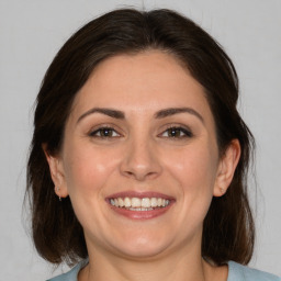 Joyful white adult female with medium  brown hair and brown eyes