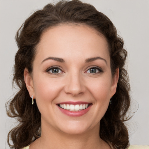 Joyful white young-adult female with medium  brown hair and green eyes