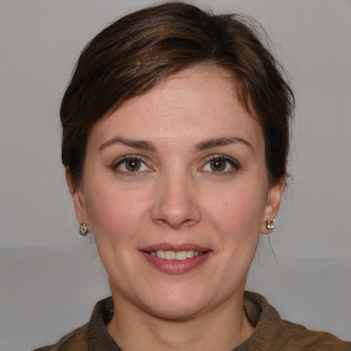 Joyful white young-adult female with medium  brown hair and grey eyes