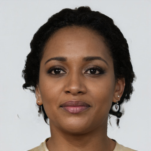 Joyful black young-adult female with short  black hair and brown eyes