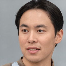 Joyful asian young-adult male with short  brown hair and brown eyes