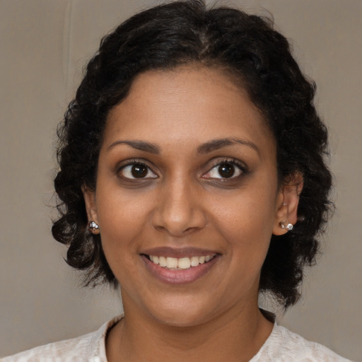 Joyful black young-adult female with medium  brown hair and brown eyes