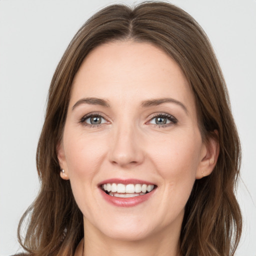 Joyful white young-adult female with long  brown hair and grey eyes