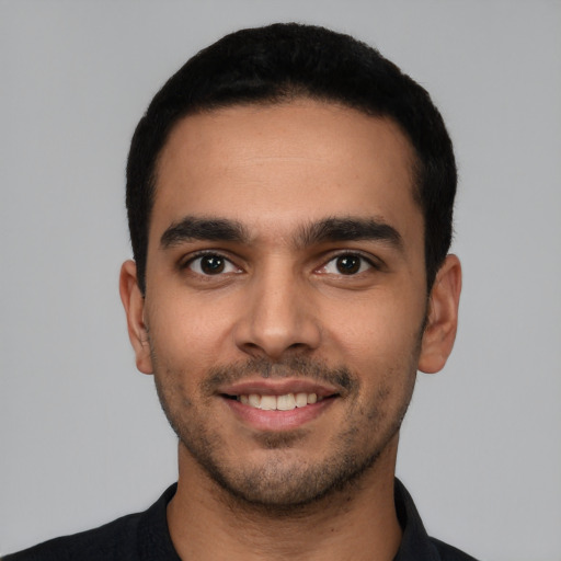 Joyful latino young-adult male with short  black hair and brown eyes