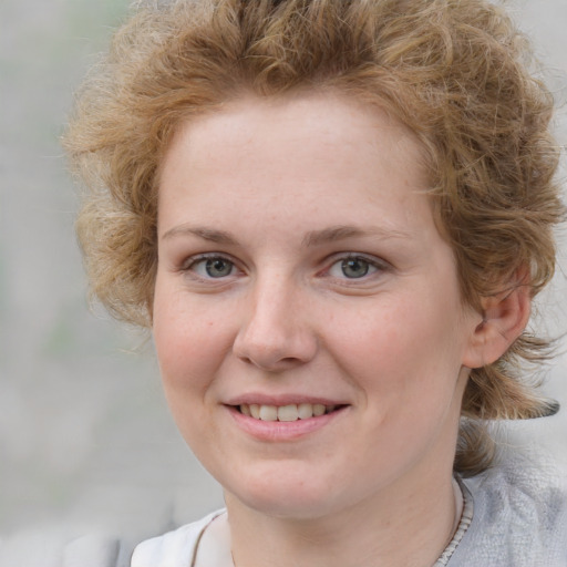 Joyful white young-adult female with medium  brown hair and blue eyes