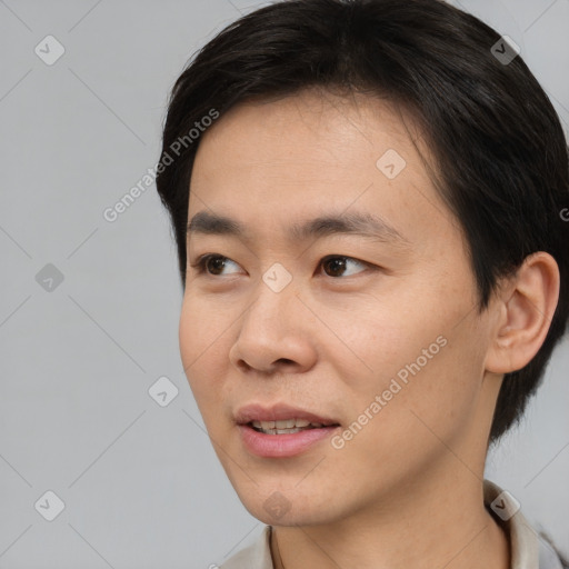 Joyful asian young-adult male with short  black hair and brown eyes