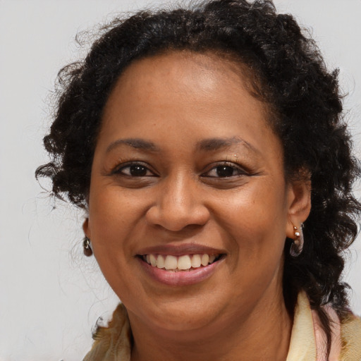Joyful black adult female with long  brown hair and brown eyes
