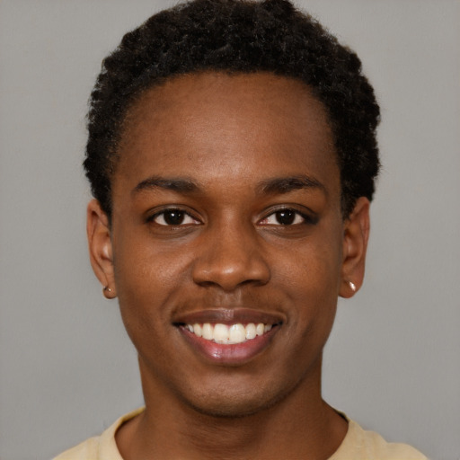 Joyful black young-adult male with short  brown hair and brown eyes