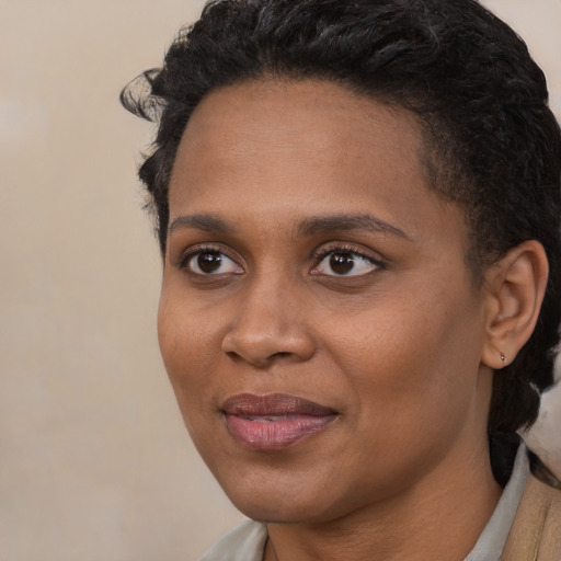 Joyful black young-adult female with short  black hair and brown eyes
