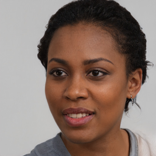 Joyful black young-adult female with short  black hair and brown eyes