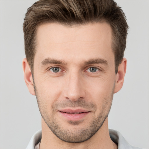 Joyful white young-adult male with short  brown hair and grey eyes