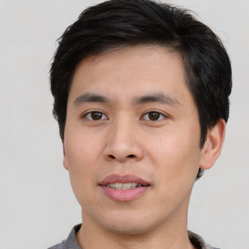 Joyful asian young-adult male with short  black hair and brown eyes