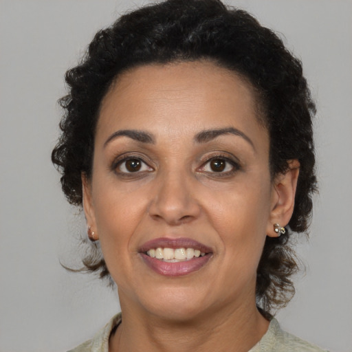 Joyful latino adult female with medium  brown hair and brown eyes