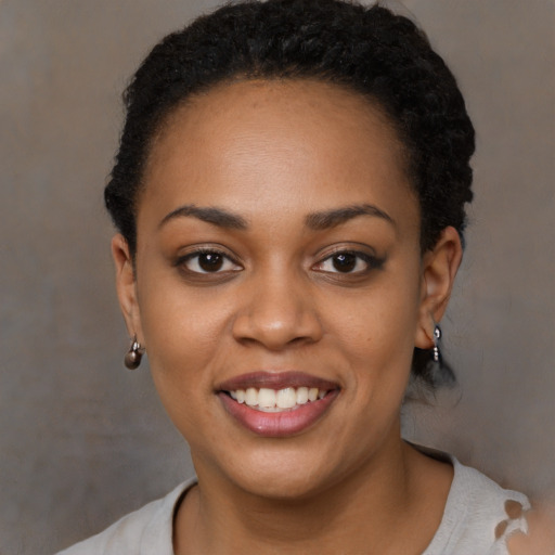 Joyful black young-adult female with short  black hair and brown eyes
