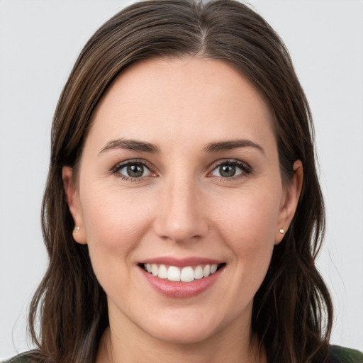 Joyful white young-adult female with long  brown hair and grey eyes