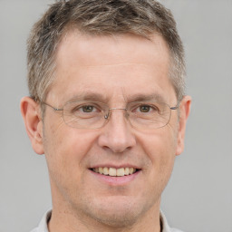 Joyful white adult male with short  brown hair and grey eyes