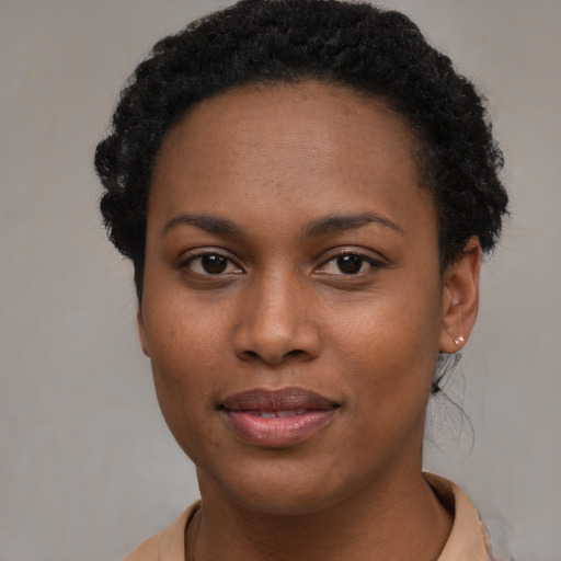 Joyful black young-adult female with short  brown hair and brown eyes