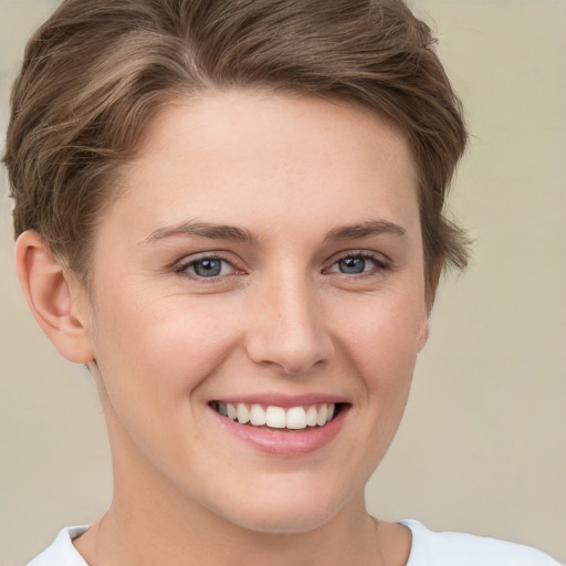 Joyful white young-adult female with short  brown hair and grey eyes