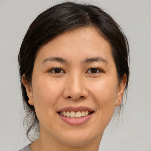 Joyful asian young-adult female with medium  brown hair and brown eyes