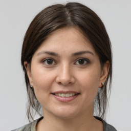 Joyful white young-adult female with medium  brown hair and grey eyes