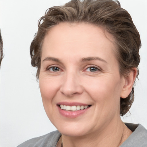 Joyful white adult female with medium  brown hair and grey eyes