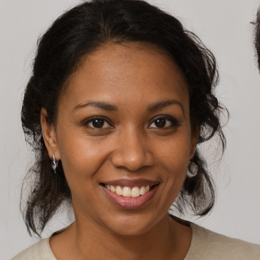 Joyful black adult female with medium  brown hair and brown eyes