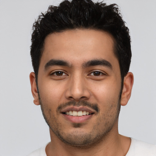 Joyful latino young-adult male with short  black hair and brown eyes