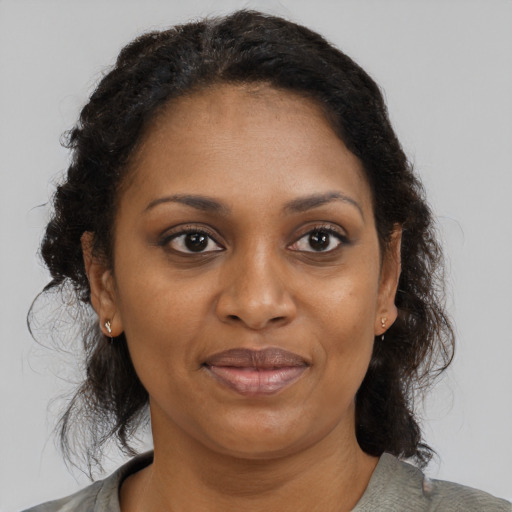 Joyful black adult female with medium  brown hair and brown eyes