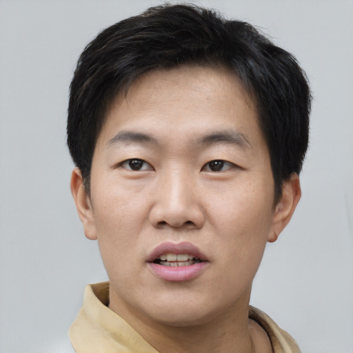 Joyful asian young-adult male with short  brown hair and brown eyes