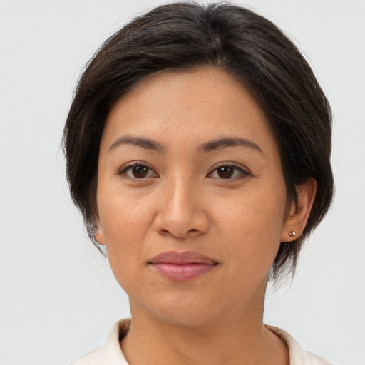 Joyful asian adult female with medium  brown hair and brown eyes