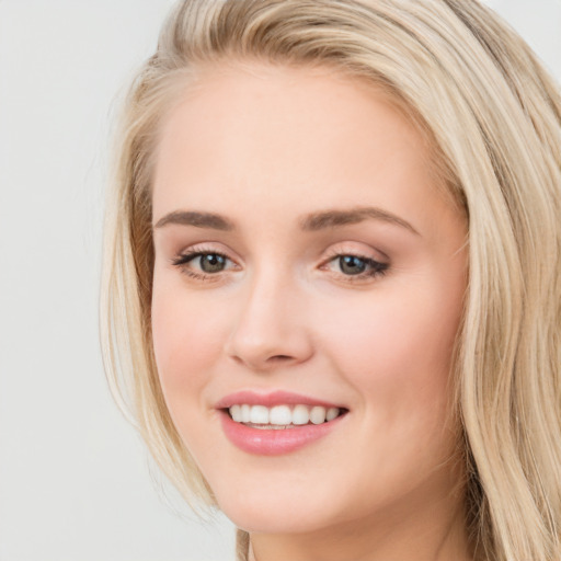 Joyful white young-adult female with long  brown hair and blue eyes