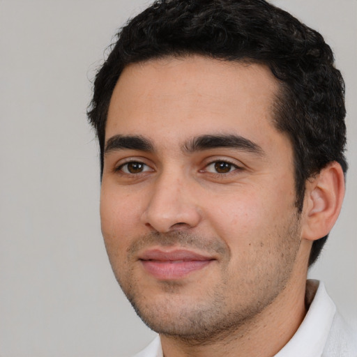 Joyful white young-adult male with short  black hair and brown eyes
