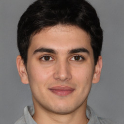 Joyful latino young-adult male with short  brown hair and brown eyes