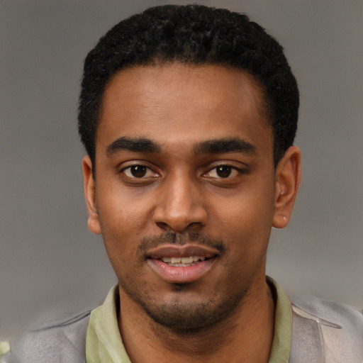 Joyful black young-adult male with short  black hair and brown eyes