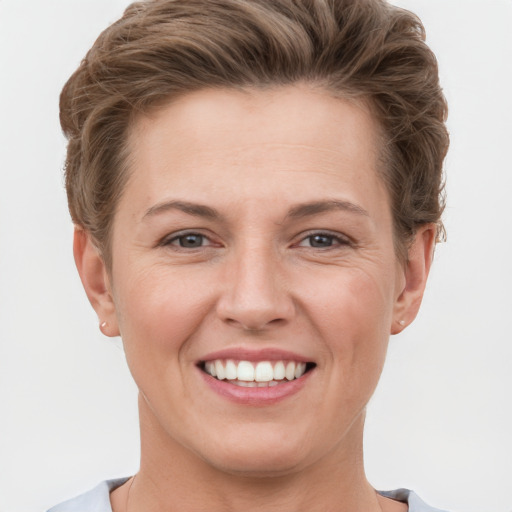 Joyful white young-adult female with short  brown hair and grey eyes