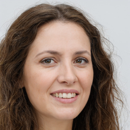 Joyful white young-adult female with long  brown hair and green eyes