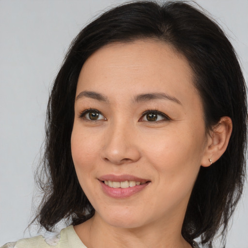 Joyful asian adult female with medium  brown hair and brown eyes