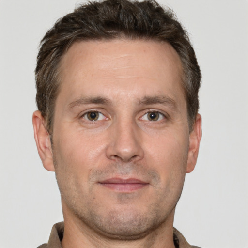 Joyful white adult male with short  brown hair and brown eyes