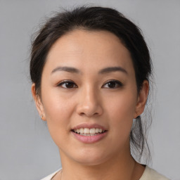 Joyful asian young-adult female with medium  brown hair and brown eyes