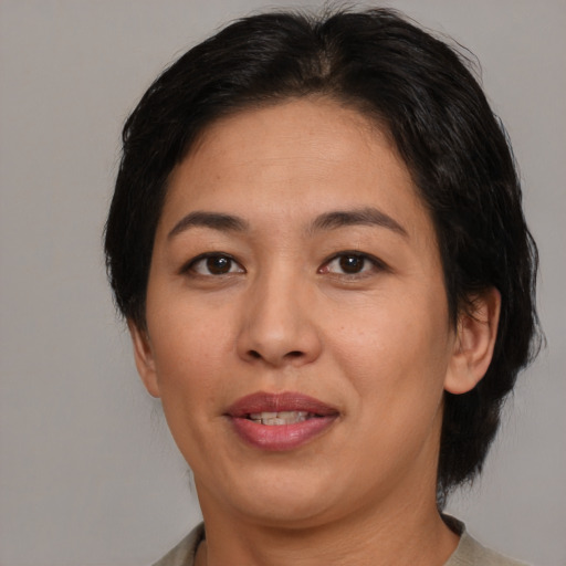 Joyful latino adult female with medium  brown hair and brown eyes